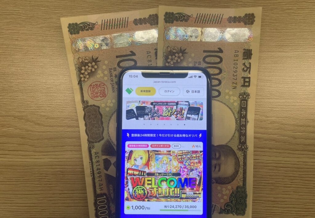 日本トレカセンターのページを開いたスマホと現金2万円